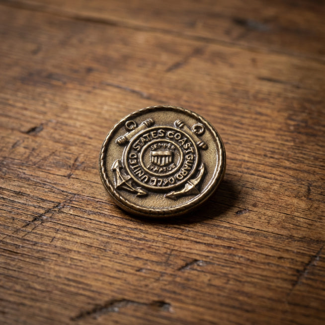 Bronze United States Coast Guard emblem on a wooden surface